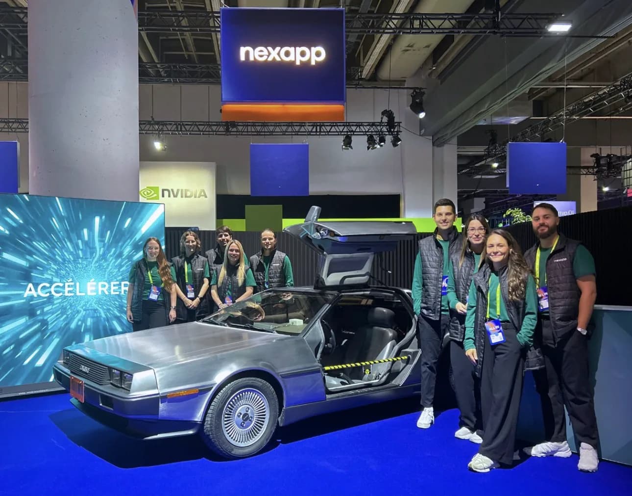 Kiosque Nexapp au salon ALL IN 2026 : enseigne de marque, mur LED Pixanova et voiture DeLorean exposée